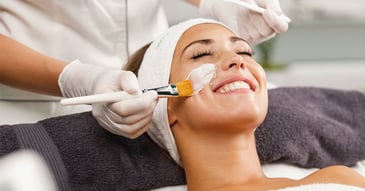 female patient having product applied to face by a specialist