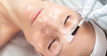 specialist applying skincare treatment to patients face