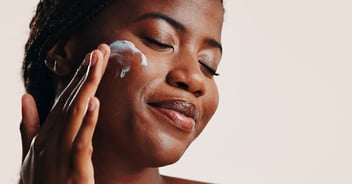 woman applying sunscreen to face