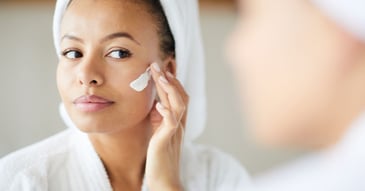 woman applying face cream during morning routine