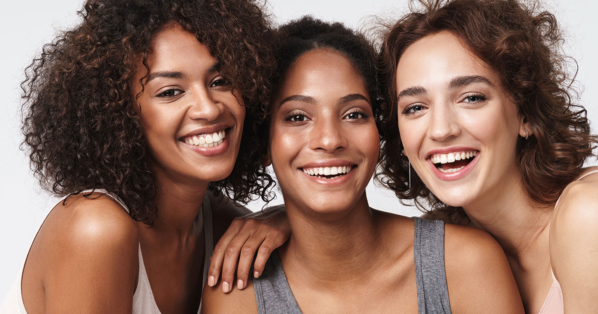 Portrait of young multiracial women standing together and smiling