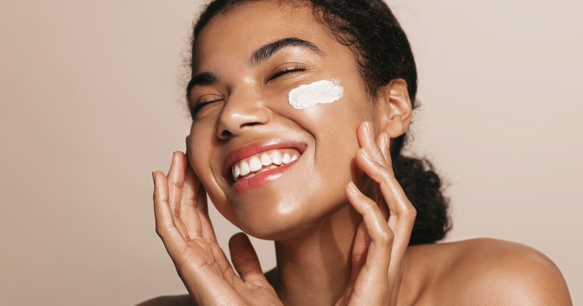 Smiling woman using skincare product